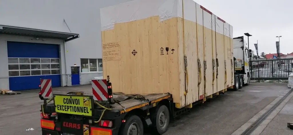 Fertig verpackte Werkzeugmaschine auf dem Tieflader vor der Halle